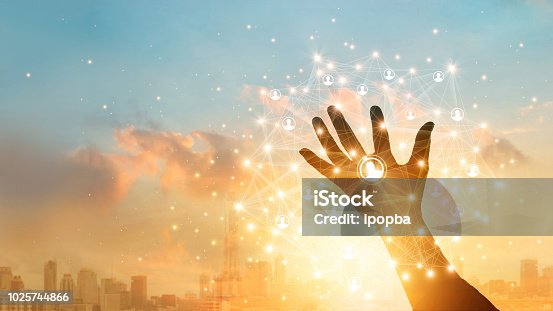 istock Businessman touching icon customer in hand with global network connection and data exchanges worldwide on city sunset background. Networking and technology concept 1025744866