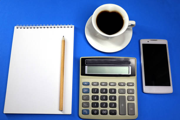 istock Notepad, pencil and calculator on colored background top view, school, business, education 1025752346