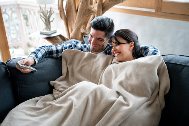 Loving couple watching television at a winter lodge