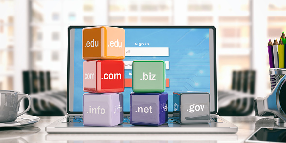 Domain names cubes on a laptop - office background. 3d illustration