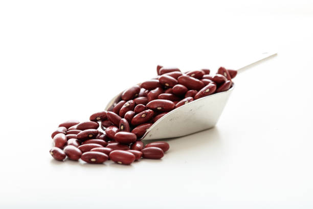 Raw red beans in a metallic scoop on white background