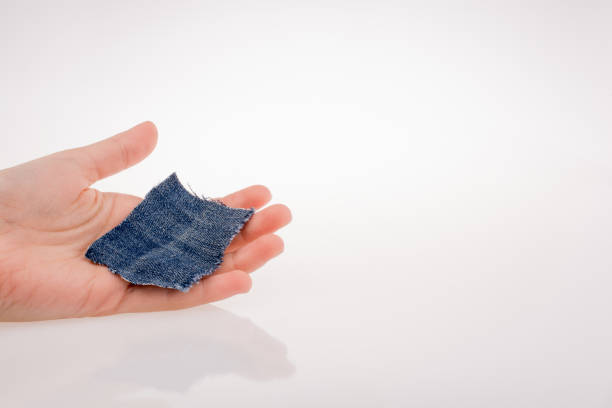 istock Denim fabric piece in hand 1025802286