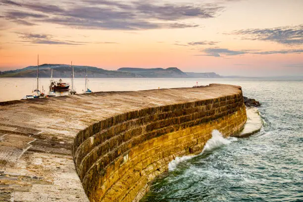 The Cobb, the historic harbour breakwater at Lyme Regis, Dorset, England, on a summer evening.