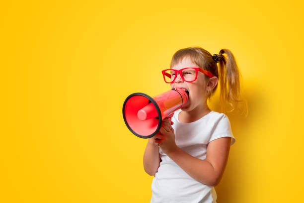 toddler girl in glasses with megaphone stock photo