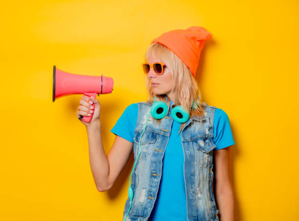 istock trendy girl orange hat with megaphone 1025821358