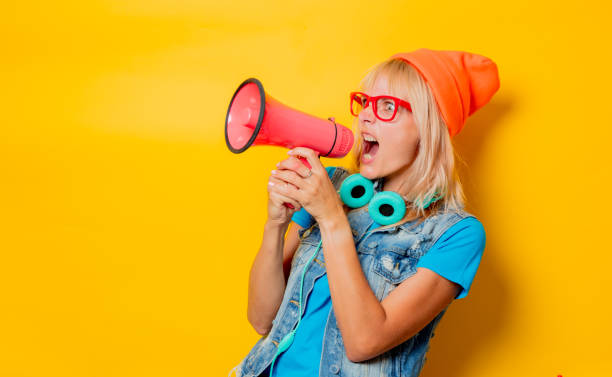 istock trendy girl orange hat with megaphone 1025821388