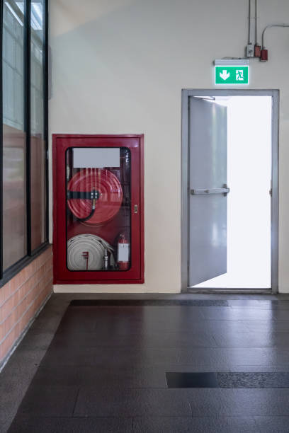 istock Fire Hose Cabinet on orange bricks floor against white concrete wall. 1025831100