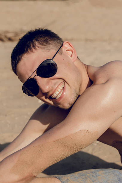 istock beach man relaxing by the beach while on vacation 1025833644