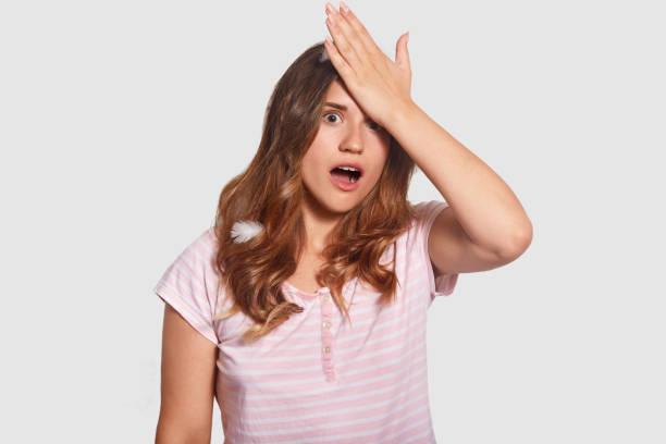istock Forgetful Caucasian female overslept important meeting, keeps hand on forehead, has surprised desperate expression, wears pyjamas, isolated over white background. People and emotions concept 1025834706