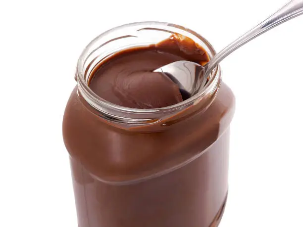 Jar of Chocolate spread with spoon, isolated on white