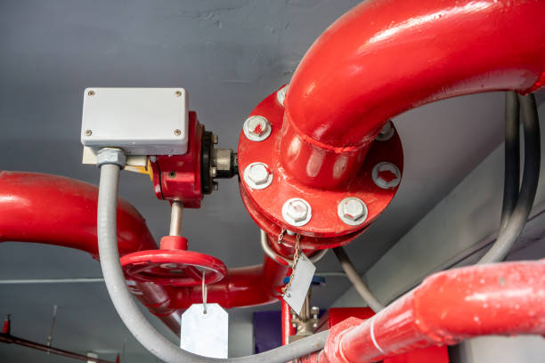 istock Industrial steel pipes in red L shape on white ceiling background. 1025848540