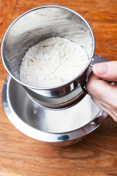 istock sifting the flour through steel sifter into bowl 1025858476