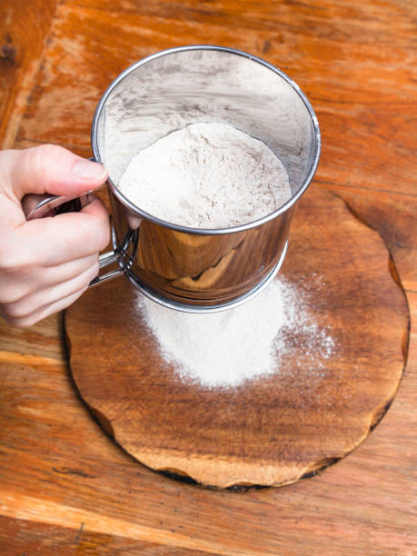 istock sifting the flour through sifter on wooden board 1025864126