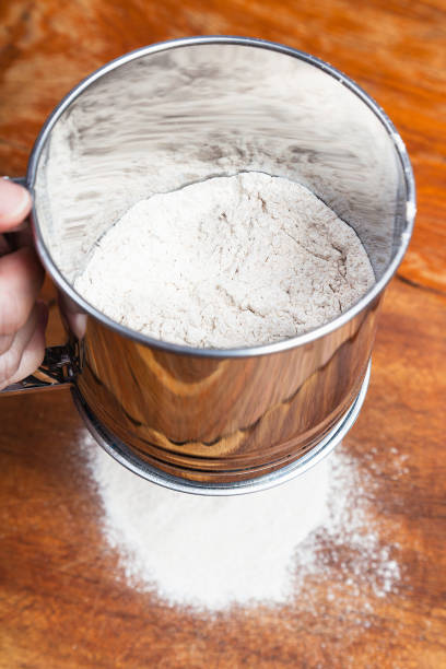 istock sifting the flour through sifter on wooden table 1025864516