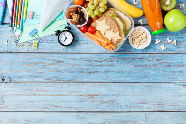 Back to school concept. Healthy lunch box and colorful stationery background. Back to school concept. Healthy lunch box and colorful stationery on turquoise wooden table top view. food elementary student healthy eating schoolboy stock pictures, royalty-free photos & images