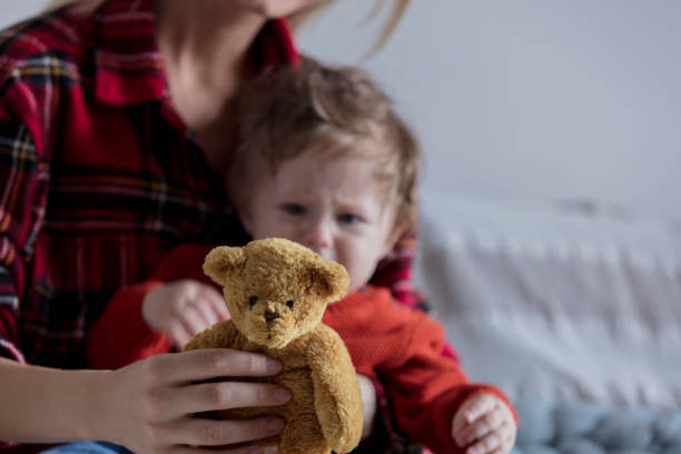 istock mother holding a teddy bear in hand. 1025878488