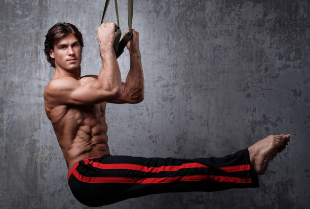 Man during workout with suspension straps Muscular man during workout with suspension straps chest dip on athletic workout stock pictures, royalty-free photos & images