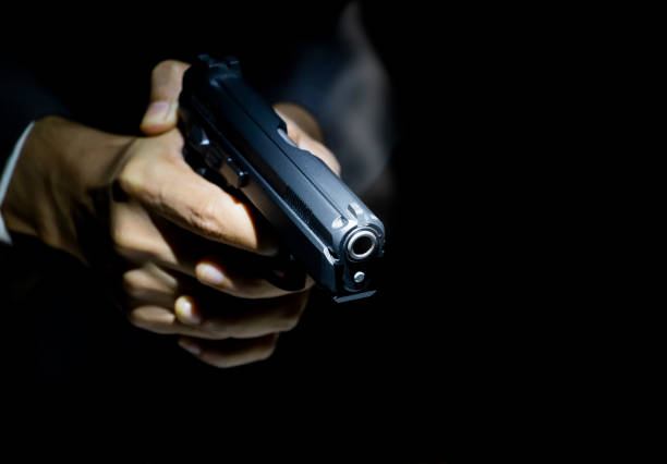 istock male hand holding gun 1025908114
