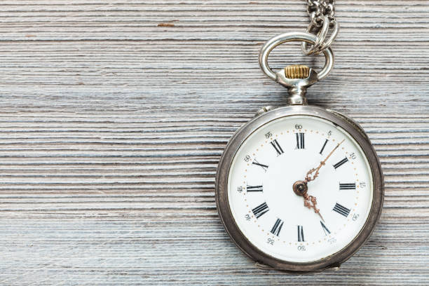 istock retro pocket watch on gray wooden table 1025915248
