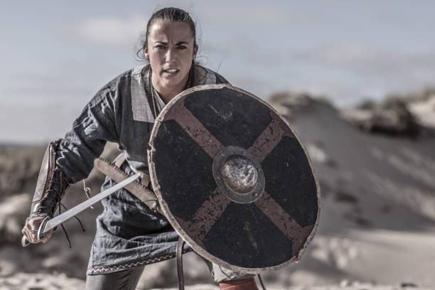 Viking woman in the sand An individual viking warrior female in action on a sandy battlefield dune fighting stance stock pictures, royalty-free photos & images