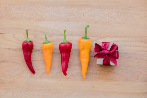 yellow and red peppers with gift box on wooden table. Above view