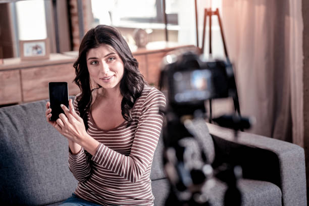 istock Cheerful vlogger holding her phone 1025934152