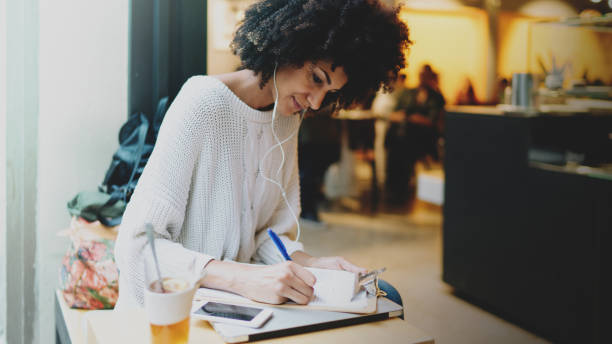 istock Successful entrepreneur female wearing stylish clothes planning working week while sitting in a modern city coffee shop on a weekend day. Marketing specialist analyzing market data. 1025934258