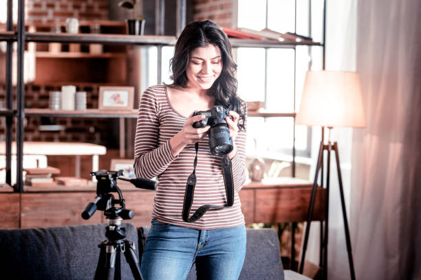 istock Joyful woman looking through photos on her cam 1025934564