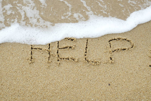 HELP The word HELP written on sand being washed away by wave suicide photos stock pictures, royalty-free photos & images
