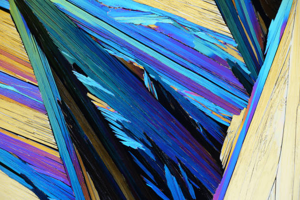 Photo through a microscope of crystals growing from the melt of alumoammonium alum. Polarized light technology stock photo