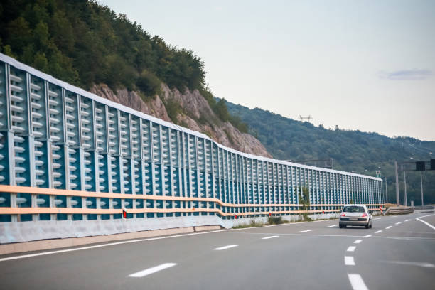 Rear view of car driving on the highway with noise barrier.