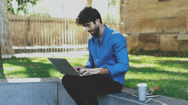 istock International student using laptop connected to wifi for booking the hostels for his weekend journey to a new country. Businessman typing emails on a portable computer during outdoor coffee break. 1025945298