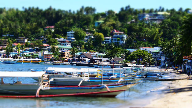 barche nel villaggio di sabang beach, puerto galera, oriental mindoro, filippine - puerto galera foto e immagini stock