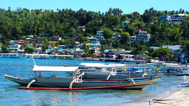 barche nel villaggio di sabang beach, puerto galera, oriental mindoro, filippine - puerto galera foto e immagini stock