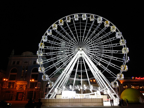 The Ferris wheel on Podol, Kiev, Ukraine. Podol is a historic neighborhood in Kiev, the capital of Ukraine. It is one of the oldest neighborhoods of Kiev, and the birthplace of the city's trade, commerce and industry. After the Mongol invasion of Rus' and destruction of Kiev, it served as a city center until the 19th century. Here was located the city administration (magistrate), main university and later here was established the city's port and shipyard.