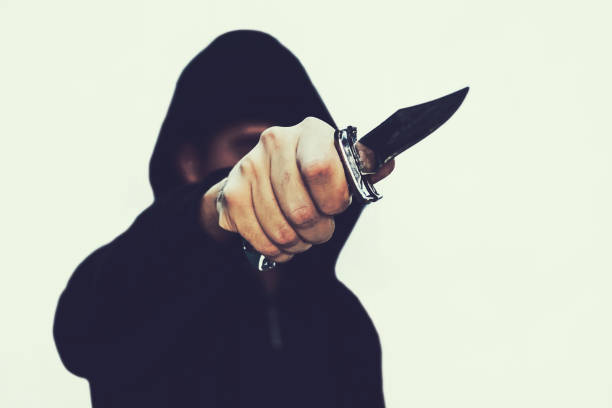 photo of a hooded man with a knife photo of a hooded man with a knife. A prisoner with a Shiv. The threat of a cold weapon. A terrorist from ISIS on a white isolated background wrongdoer stock pictures, royalty-free photos & images