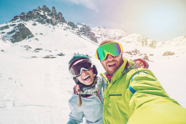 dos jóvenes tomando selfie de pistas de esquí en suiza, vacaciones de turistas par disfrutar los alpes suizos y el concepto de vacaciones de esquí - st moritz engadine mountain winter fotografías e imágenes de stock