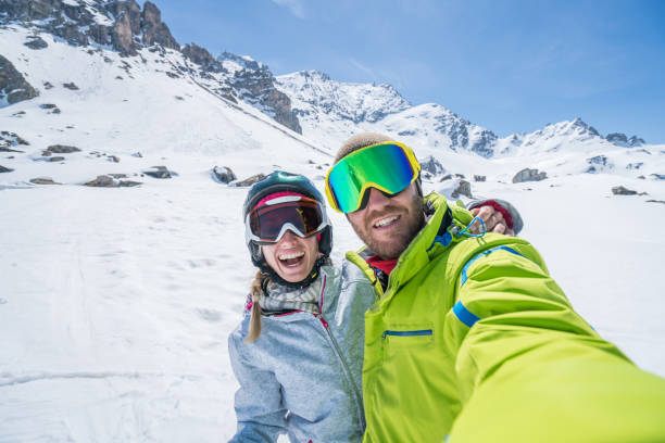 dos jóvenes tomando selfie de pistas de esquí en suiza, vacaciones de turistas par disfrutar los alpes suizos y el concepto de vacaciones de esquí - st moritz engadine mountain winter fotografías e imágenes de stock