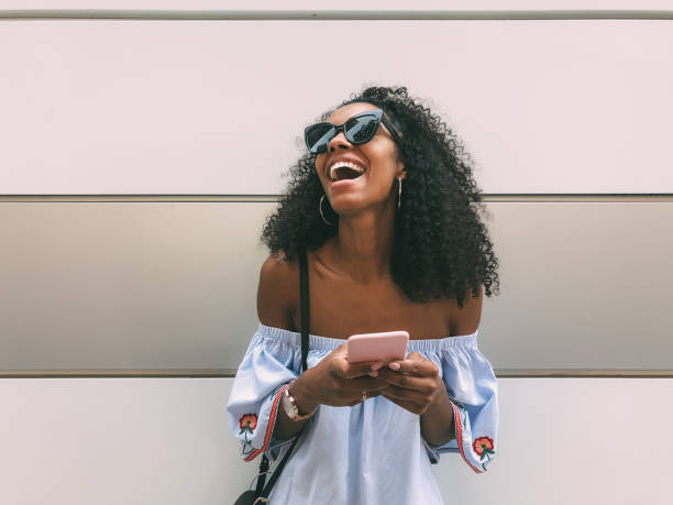 Cheerful black woman with mobile phone