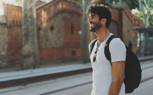 istock Young talented designer exploring unknown city to inspire with a new ideas for the next projects. Successful IT specialist with a backpack on his back visiting new cities during summer vacation. 1025959078