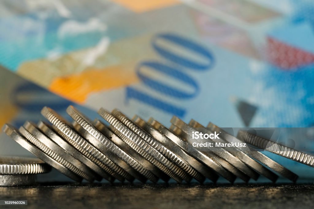 Swiss coins and Swiss banknote Various Swiss coins visible against background of one hundred francs banknote Bank Account Stock Photo
