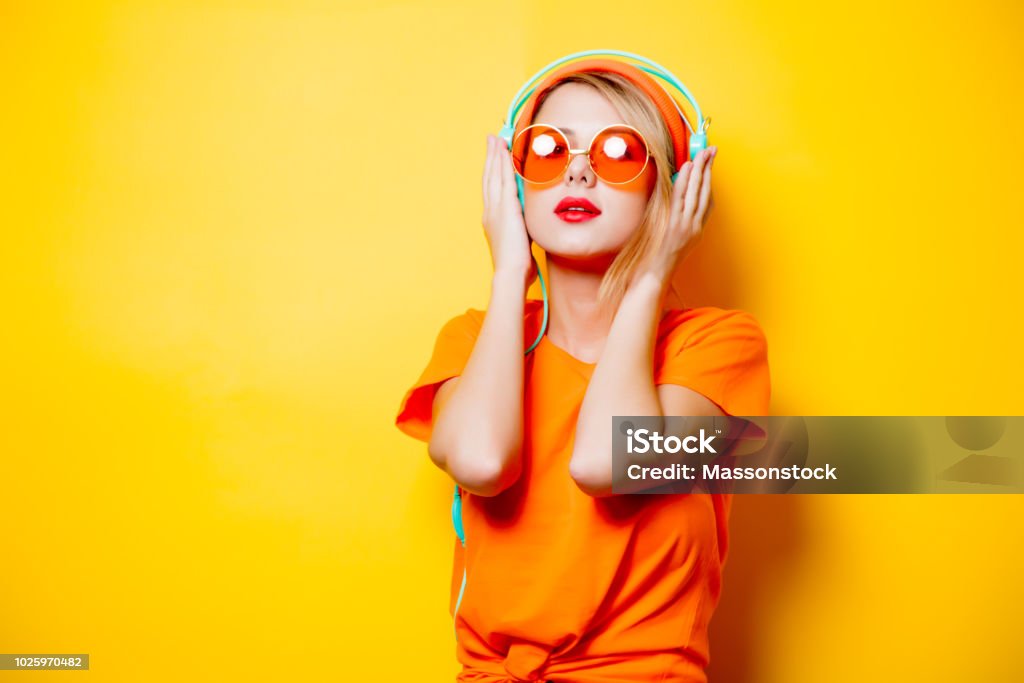 オレンジ色のメガネとヘッドフォン少女 - オレンジ色のロイヤリティフリーストックフォト