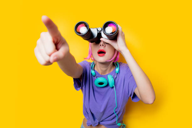 istock Young style girl in purple clothes with binoculars 1025970710