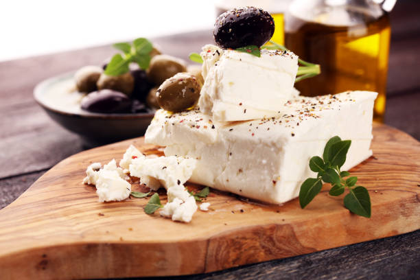 istock Greek cheese feta with herbs and olives on rustic table. 1025979362