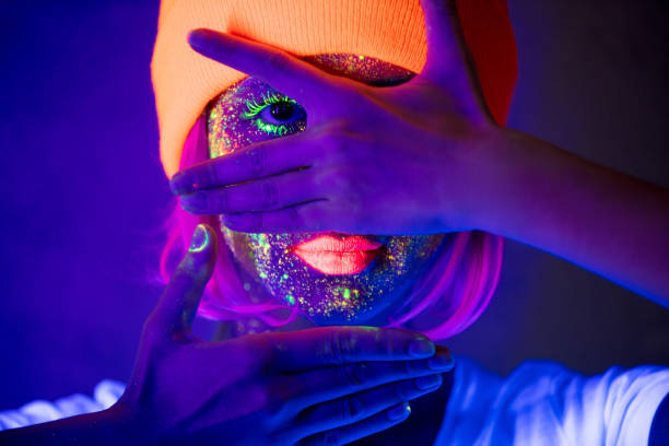 Young girl in hat with fluorescent paint stock photo