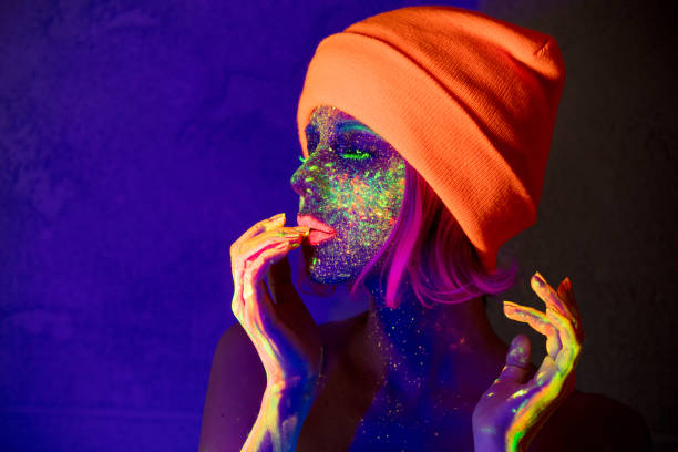istock Young girl in hat with fluorescent paint 1025979424