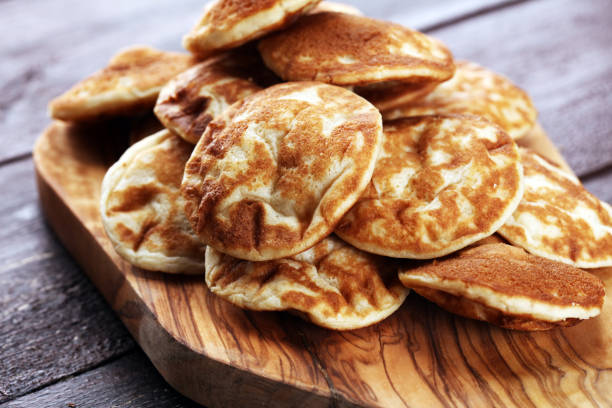 istock Pancakes or puffertjes with berries and maple syrup on rustic table 1025979912