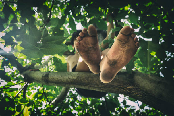 Child playing in the field with dirty feet.