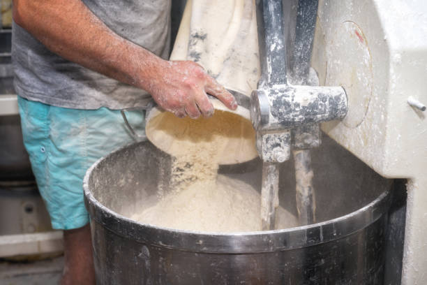 istock Loading flour into an industrial bakery dough mixer. 1025992472