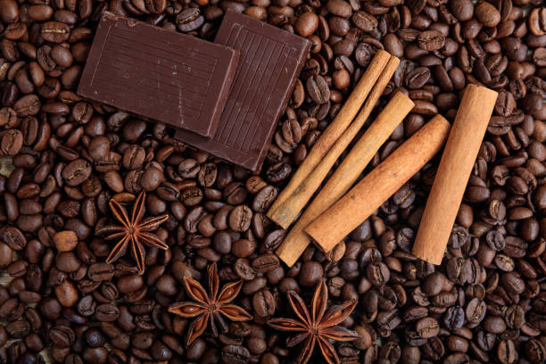 Chocolate bars and cinnamon sticks on coffee beans background